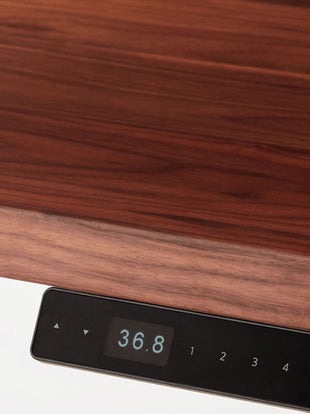 Vue latérale en gros plan d'un bureau debout Jarvis en bois dur d'Herman Miller, montrant la texture et la finition du plan de travail.